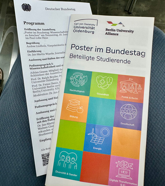 Ein Programmheft für eine Veranstaltung im Deutschen Bundestag, das Informationen über die Ausstellung und beteiligte Studierende enthält. Auf der Vorderseite sind bunte Symbole zu Themen wie Nachhaltigkeit, Gesundheit, Bildung und digitale Transformation abgebildet.